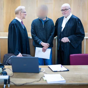 Der Angeklagte (M) steht im Gerichtssaal zwischen seinen Verteidigern Steffen Stern (l) und Matthias Waldraff (r).