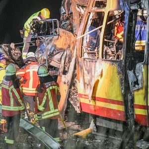 Eine völlig zerstörte Stadtbahn und ein umgekippter Laster mit rund einem Dutzend Feuerwehrleuten