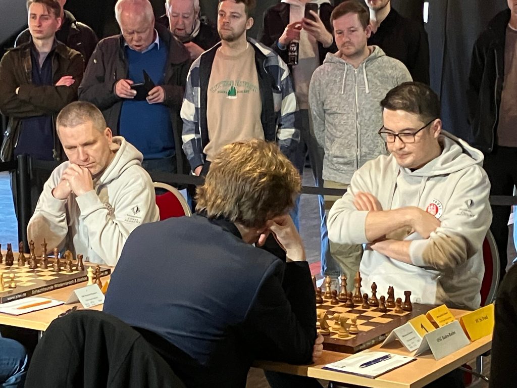 David Howell, noch mit Brille, am Spitzenbrett gegen Vincent Keymer. Neben ihm spielt Bartosz Socko an Brett drei.