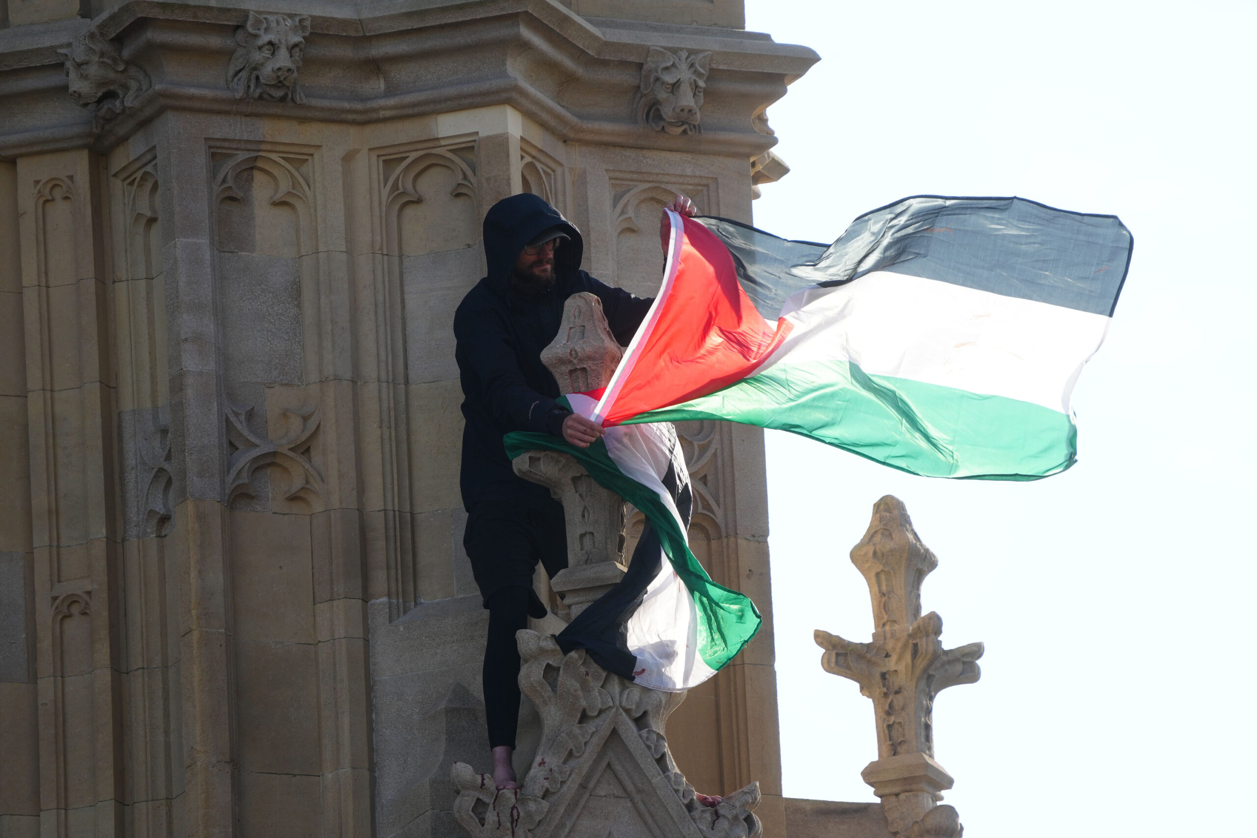 Ein Mann hält eine palästinensische Flagge in der Hand, nachdem er auf den Big Ben in London geklettert ist.