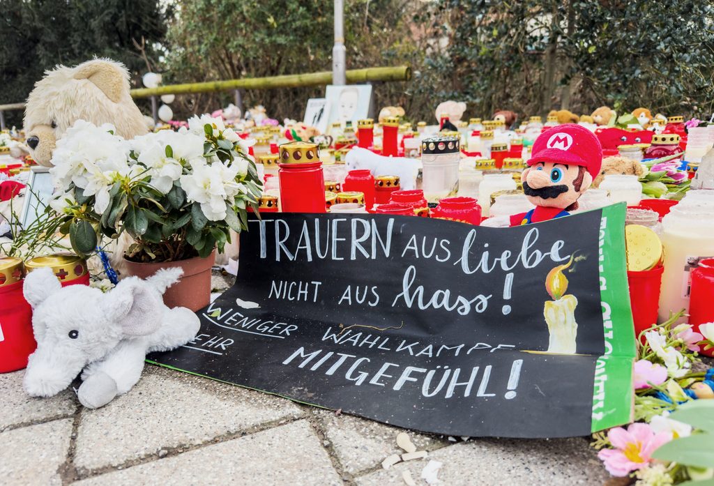 Nach dem tödlichen Messerangriff in Aschaffenburg liegt am Tatort ein Plakat mit der Aufschrift: „Trauern aus Liebe nicht aus Hass! Weniger Wahlkampf mehr Mitgefühl!“