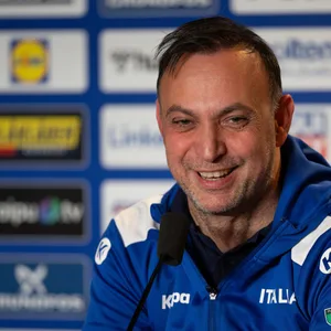 Bob Hanning lacht auf einer Pressekonferenz als Italiens Nationaltrainer.