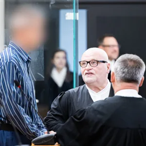 Der Angeklagte steht in einem Gerichtssaal im Landgericht Hannover. Daneben stehen seine Anwälte.