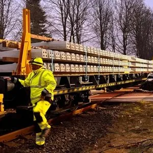Einsatzkräfte arbeiten am Einsatzort, nachdem eine Autofahrerin am Bahnübergang in einen Arbeitszug gefahren ist.