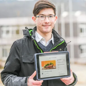 Lucas Fuchs hält ein Tablet, das eine online-Petition zeigt. Der 18-Jährige hat die Petition, die mehr als 560 Stimmen bekommen hat, initiiert, um für einen Dönerladen in Essingen zu werben.