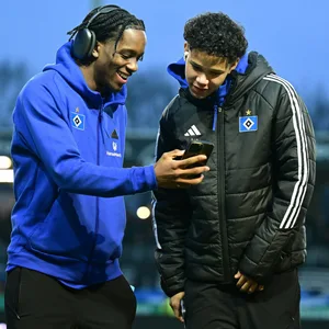 Adedire Mebude zeigt Alexander Røssing-Lelesiit etwas auf seinem Smartphone