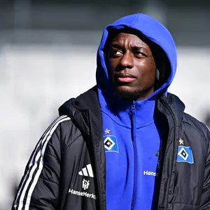 Jean-Luc Dompé guckt mit Kapuze auf dem Kopf durchs Stadion