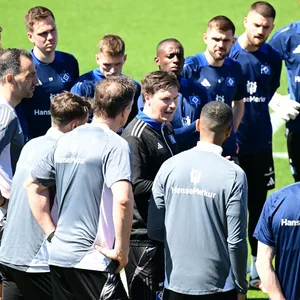Merlin Polzin spricht neben den HSV-Profis im Teamkreis
