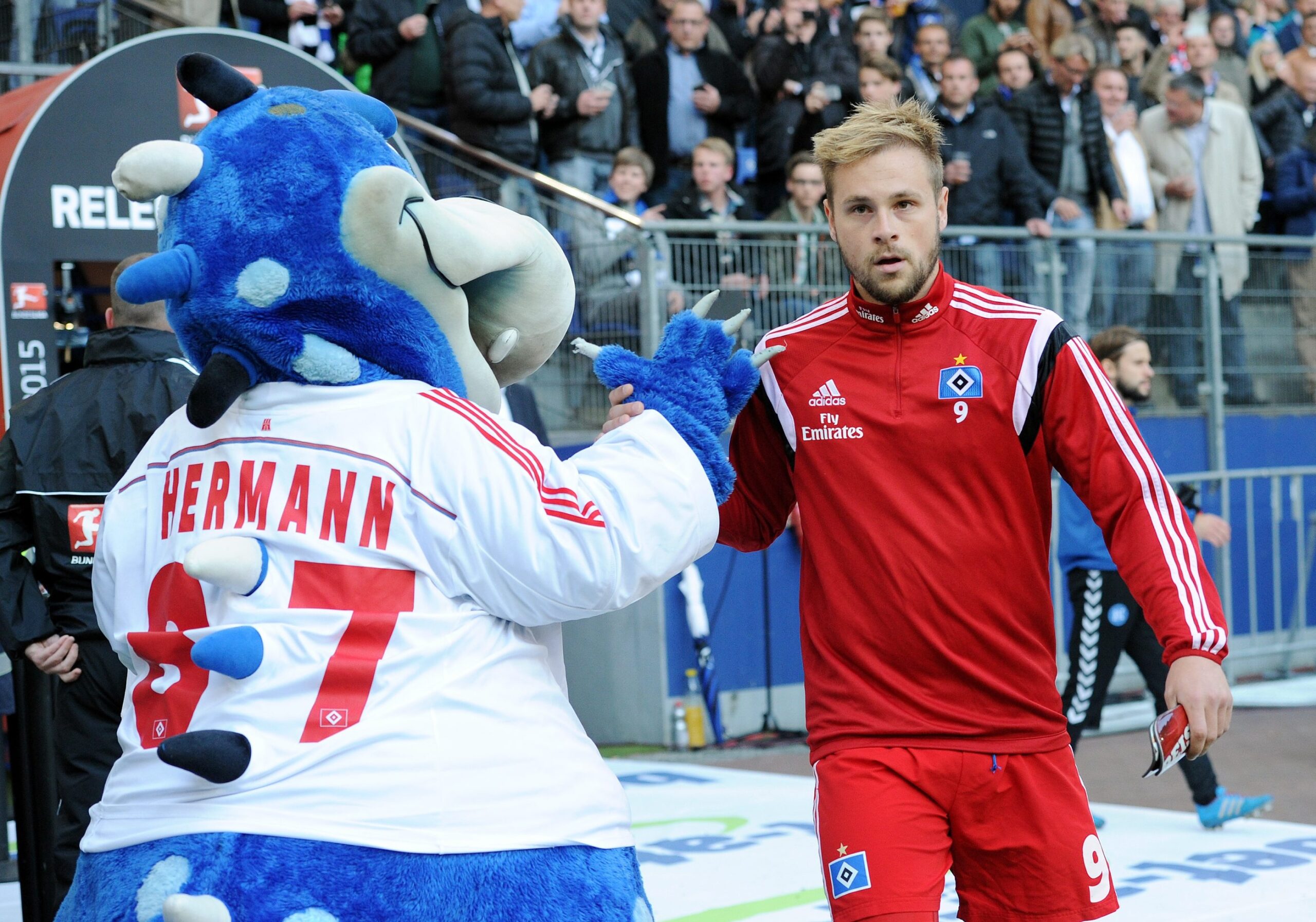 Maximilian Beister gibt dem HSV-Maskottchen „Dino Hermann“ die Hand