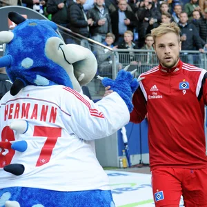 Maximilian Beister gibt dem HSV-Maskottchen „Dino Hermann“ die Hand