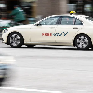 Ein Taxi im Auftrag von Freenow fährt über eine Straße.