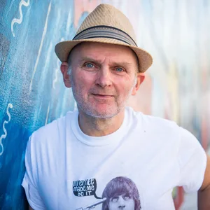 Jim Avignon, Künstler, steht vor seinem Werk an der East Side Gallery.