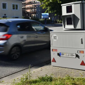 Ein Auto fährt an einem mobilen Blitzer vorbei.