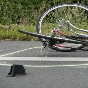 Radfahrer starrt auf das Handy und hat Kopfhörer auf. Dadurch verursacht er schweren Unfall und flüchtet