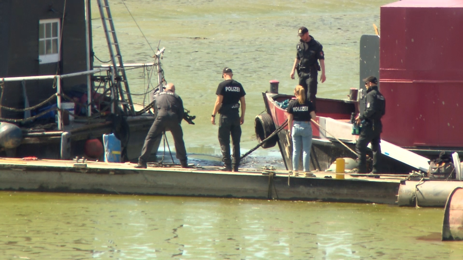 Beamte des Hamburger LKA durchsuchen den Schlick rund um das Hausboot der getöteten Autorin Alexandra Fröhlich nach Beweismitteln.