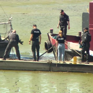 Beamte des Hamburger LKA durchsuchen den Schlick rund um das Hausboot der getöteten Autorin Alexandra Fröhlich nach Beweismitteln.