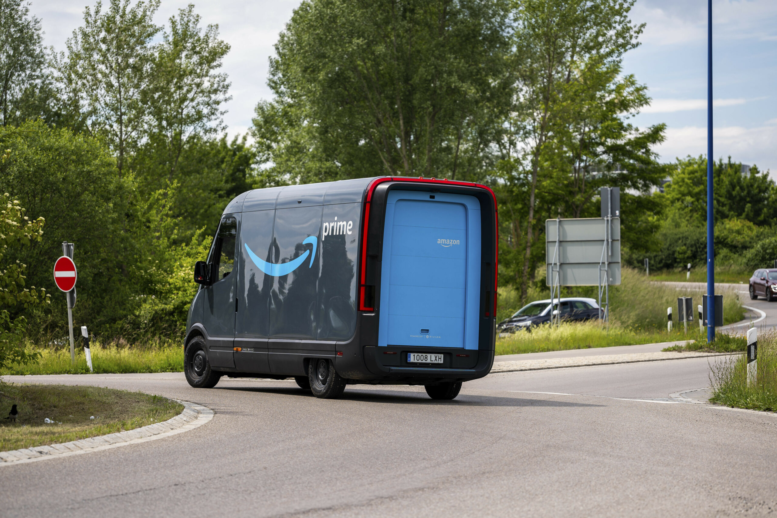 Ein Amazon Lieferwagen fährt im Kreisverkehr, Fahrzeug LKW mit der Aufschrift Amazon Prime