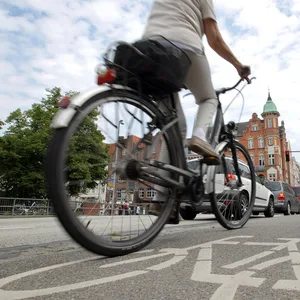 Eine Frau fährt mit ihrem Fahrrad durch die Lübecker Altstadt.