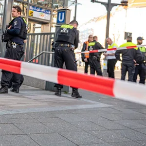 Berliner Polizisten stehen nach der Gewalttat bei dem U-Bahn-Eingang Sophie-Charlotte-Platz.