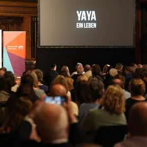 Die Gäste schauen sich die Erstaufführung des Filmes „Yaya - Ein Leben“ im Rathaus.