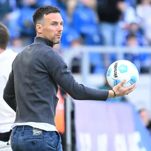 Christian Eichner hält einen Ball in der Hand