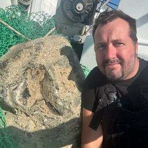 Krabbenfischer André Claußen mit dem gefangenen 70 Kilo schweren Gesteinsbrocken.