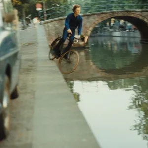 Ein Fahrradfahrer fährt in einen Kanal in Amsterdam.