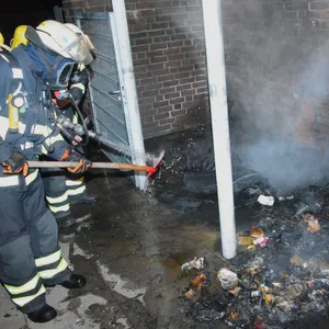 Feuerwehrleute löschen die brennenden Container neben dem Edeka in Neuallermöhe.