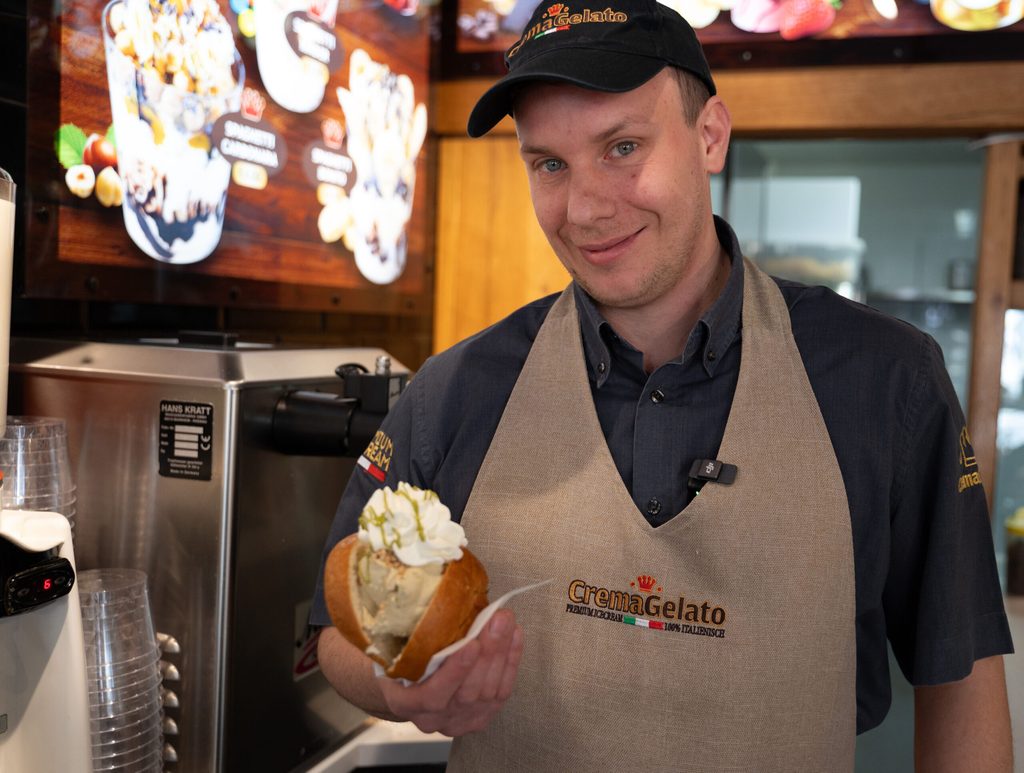 Eisdielenbetreiber Marco Caimmi hält einen „Eis-Burger“ in der Hand.