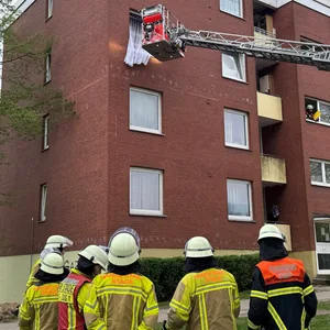 Eine Drehleiter der Feuerwehr ist am dritten Obergeschoss des Wohnhauses.