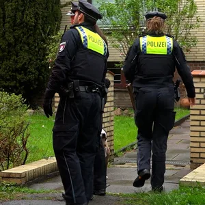 Polizisten vor einem Haus