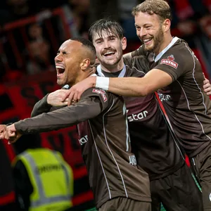 Connor Metcalfe und Carlo Boukhalfa feiern gemeinsam mit Etienne Amenyido St. Paulis Heimsieg gegen Nürnberg im Oktober 2023.