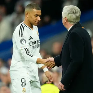Kylian Mbappé und Carlo Ancelotti geben sich die Hand.