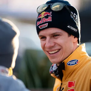 Andreas Wellinger schaut lächelnd eine Person an