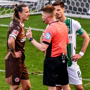 Referee Christian Dingert im Dialog mit Jackson Irvine und Julian Weigl