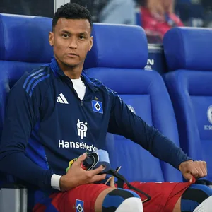 Davie Selke schaut von der HSV-Bank in die Kamera