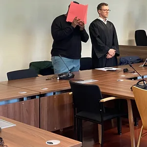 Der Angeklagte steht neben seinem Anwalt