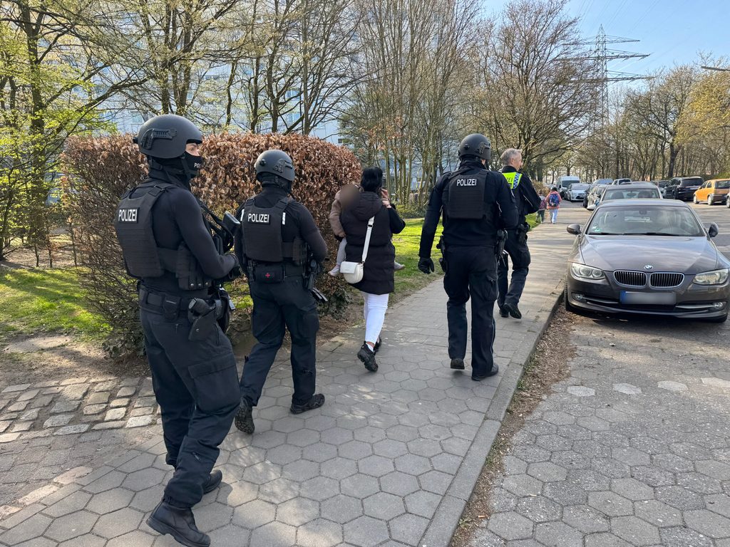 Die Polizei führt eine Frau mit Kind aus einem Wohnhaus in der Kreuzburger Straße.