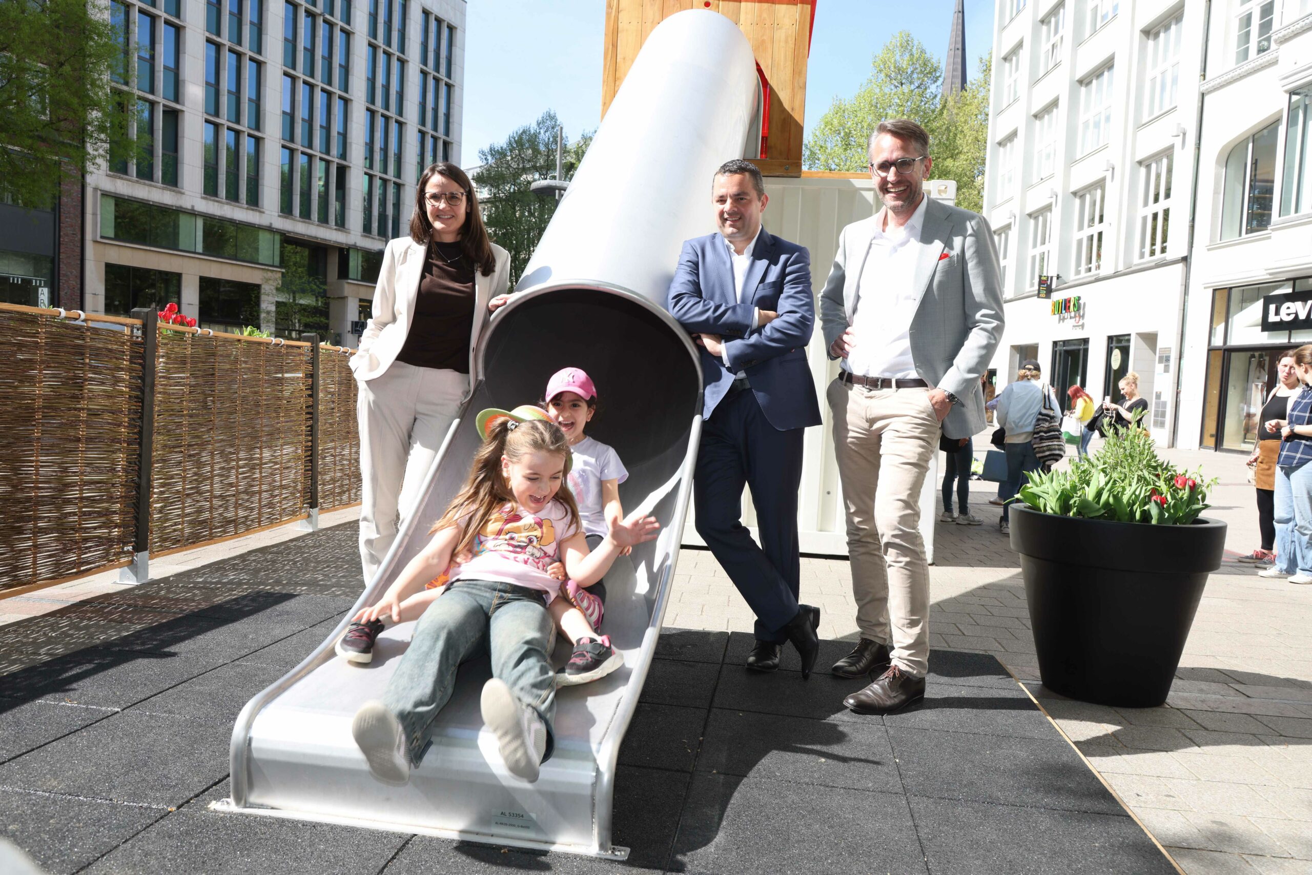 Senatorin Karin Pein, Bezirksamtsleiter Ralf Neubauer (beide SPD) mit dem Otto-Wulf-Geschäftsführer Sebastian Binger und „Testkindern“ aus der Kita St. Petri auf dem neuen Mini-Spielplatz.