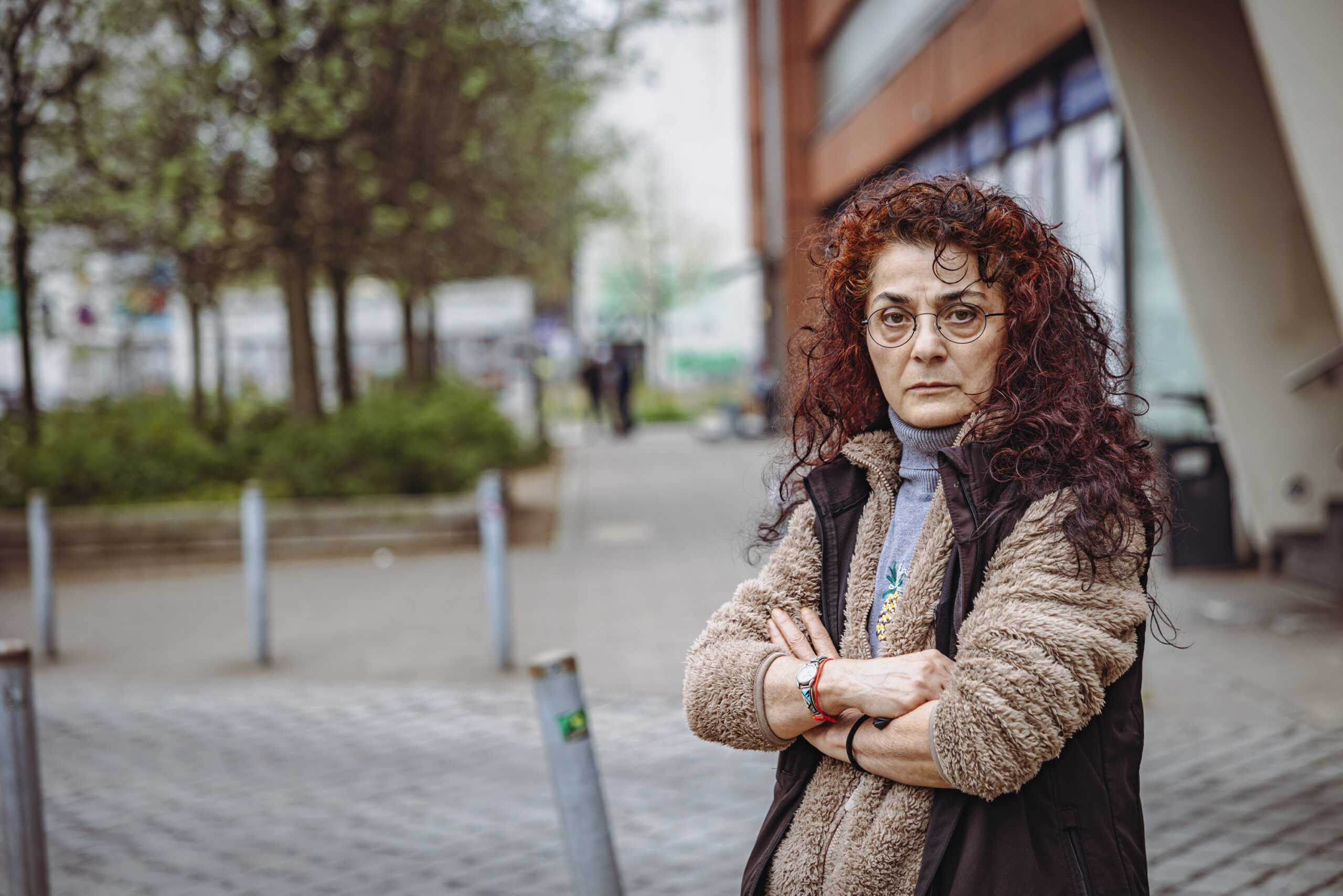 Eine Frau mit roten Locken und verschränkten Armen