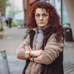 Eine Frau mit roten Locken und verschränkten Armen