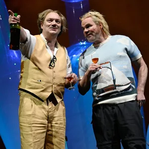 Charly Hübner und Yorck Dippe halten jeweils ein Weinglas in der Hand.