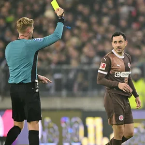 Manolis Saliakas bekommt eine Gelbe Karte gezeigt.