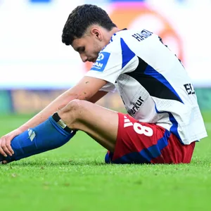 Daniel Elfadli sitzt unzufrieden auf dem Rasen des Volksparkstadions.