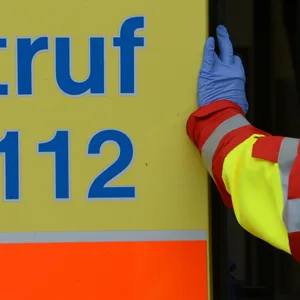 Ein Mitarbeiter des Rettungsdienstes lehnt in der Tür eines Rettungswagens. (Symbolbild)