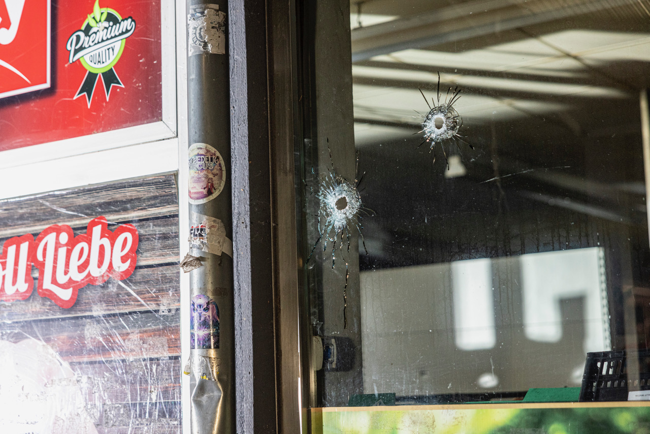 Die Einschusslöcher in der Fensterscheibe des Supermarktes