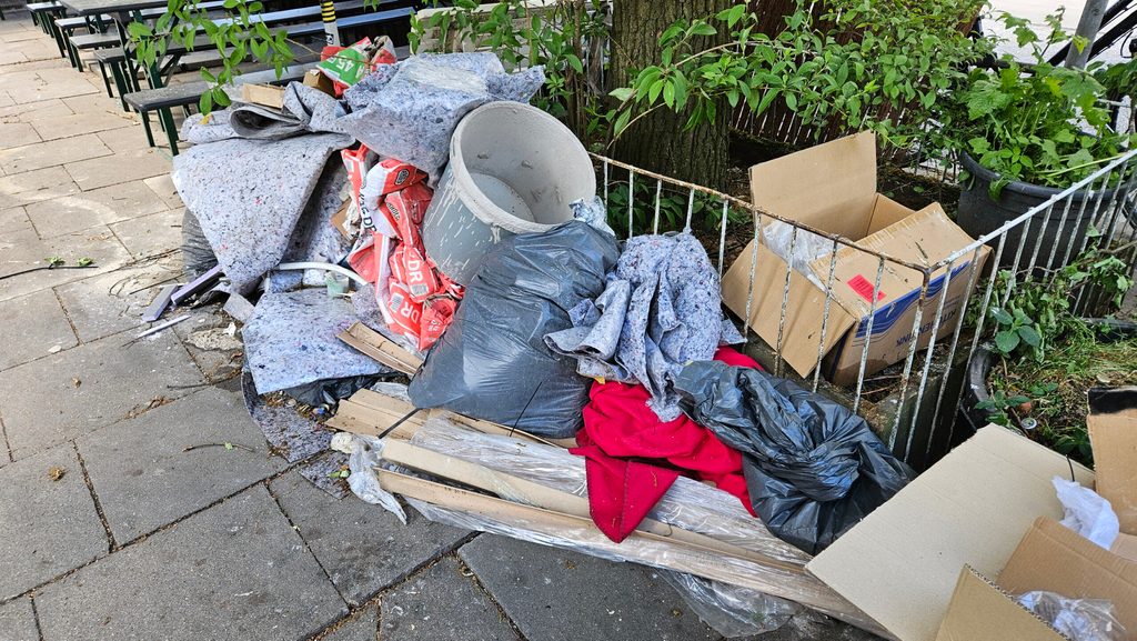 Vor der Tür im Biergarten liegt Müll, der von einer Renovierung zeugt.