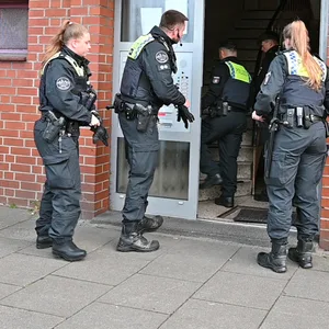 Polizeikräfte vor einem Hauseingang