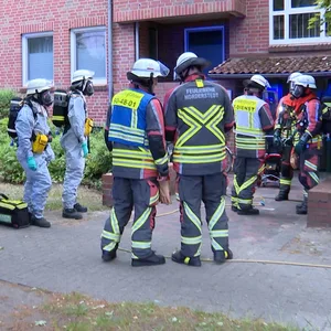 Feuerwehrleute in Schutzkleidung beim Einsatz in Friedrichsgabe in Norderstedt.