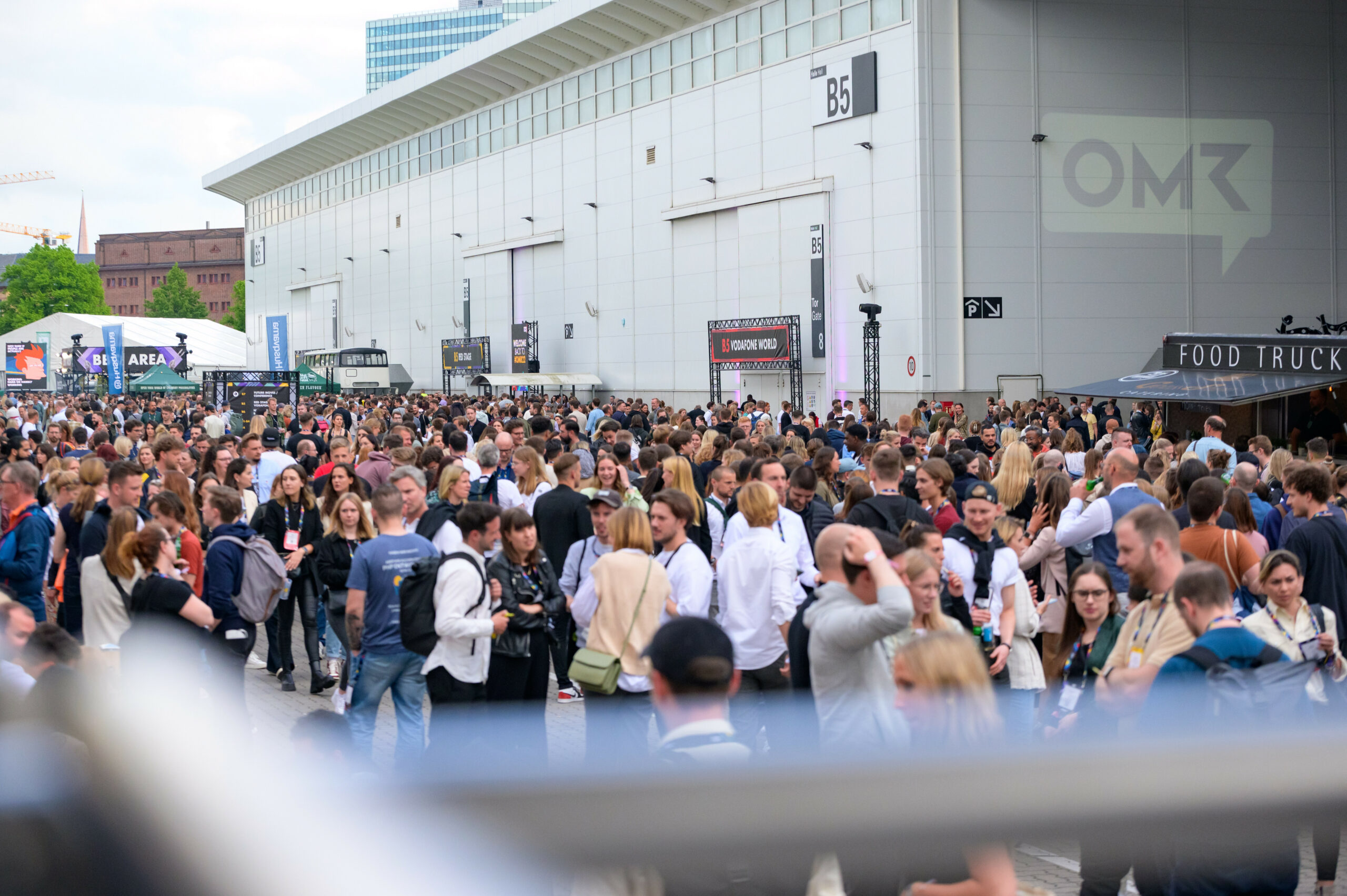 Zahlreiche Messe-Besucher stehen zwischen den Messehallen.